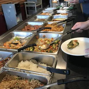 a line of food being served at a buffet