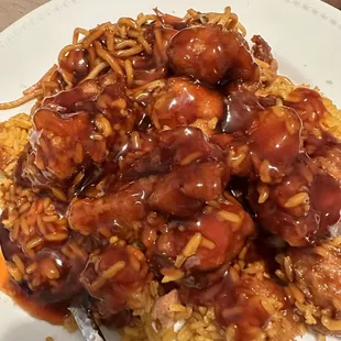 Half of the portion of General Tso chicken with pork fried rice and noodles