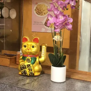 a cat statue and a vase of flowers