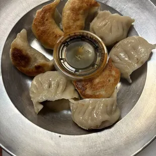 a plate of dumplings and dipping sauce