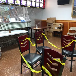 a restaurant with tables and chairs taped with yellow tape