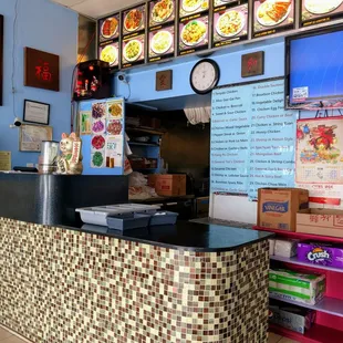 a restaurant counter with a clock on the wall