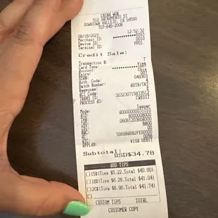 a woman's hand holding a receipt
