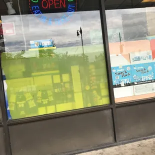 a storefront with a neon sign in the window