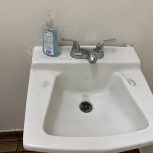 a bathroom sink with a soap dispenser