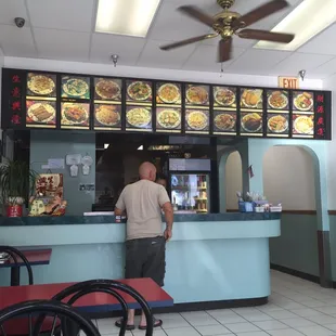 a man standing at the counter of a restaurant