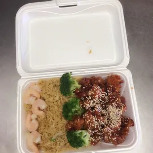 a container of food with rice and broccoli