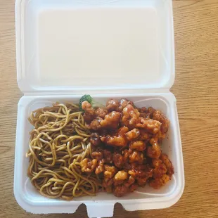 a takeout container with noodles and meat