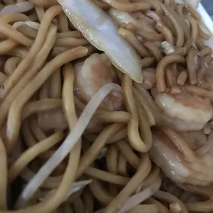 a plate of noodles with shrimp and onions