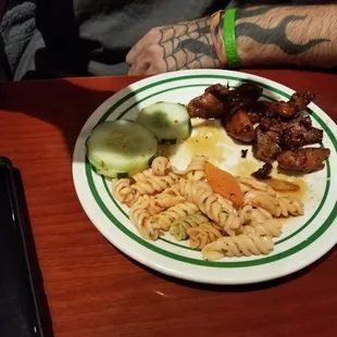 Delicious choices from the buffet here! Sliced cucumbers, peppered chicken, and noodles.