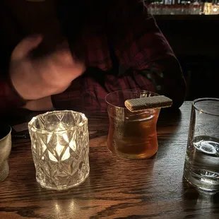 a person sitting at a table with a glass of whiskey
