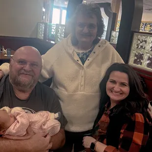 a man and woman holding a baby