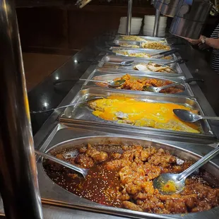 a line of food being served at a buffet