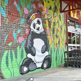 a panda bear painted on the side of a building