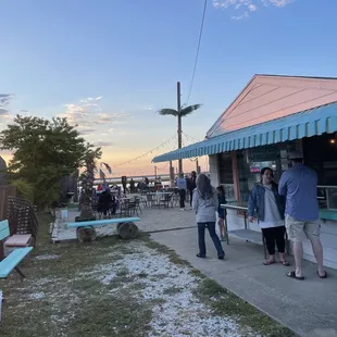 This place absolutely is open. We had burgers and beer at picnic table by the water, and enjoyed a live guitar player also.