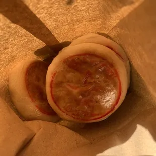 two buns in a brown paper bag