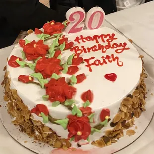 Fresh strawberry filled sponge cake with almond flakes on the side.