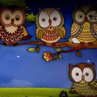 a group of owls sitting on a branch