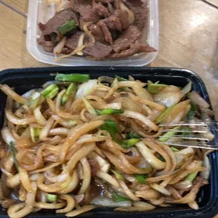 a tray of noodles and beef