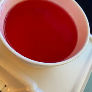 a bowl of red liquid on a tray