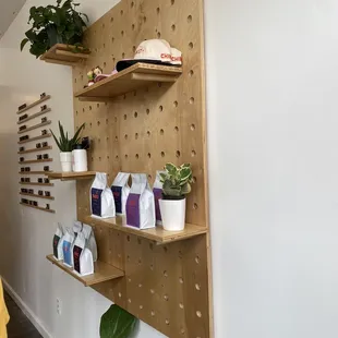 a shelf with coffee bags and plants