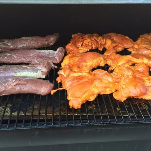 chicken and sausages cooking on the grill