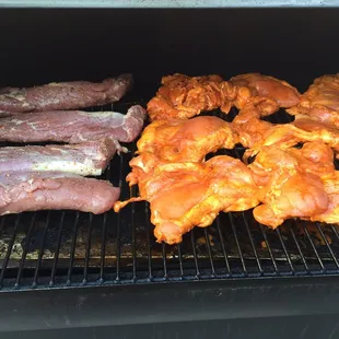 chicken and sausages cooking on the grill