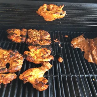 chicken and steak cooking on the grill