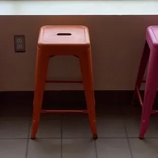 a row of stools in front of a window