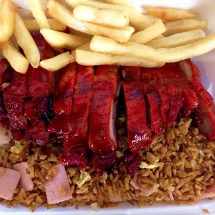 a meal of rice, meat and french fries