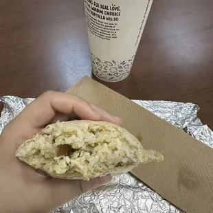 a hand holding a burrito