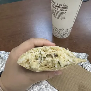 a hand holding a burrito