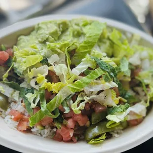 Bowl with white cilantro rice, grilled chicken, avocado, red salsa, green peppers, and pico de gayo.