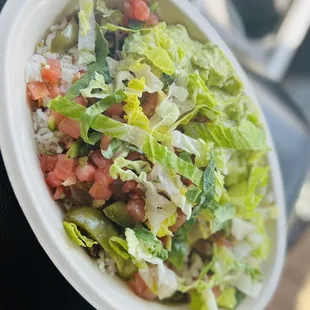 Bowl with white cilantro rice, grilled chicken, avocado, red salsa, green peppers, and pico de gayo.