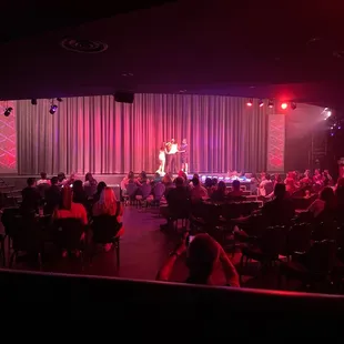 a stage with people sitting at tables