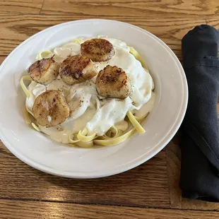 a plate of scallops and pasta