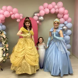 three girls dressed in princess dresses