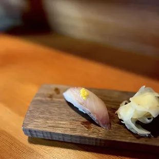 two pieces of sushi on a cutting board
