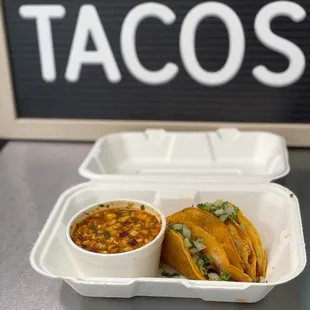 two tacos in a styrofoam container