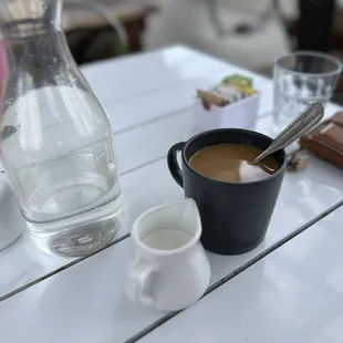 a cup of coffee and a pitcher of water