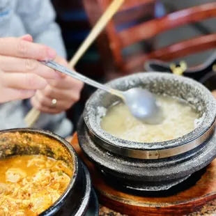 a bowl of soup with chopsticks