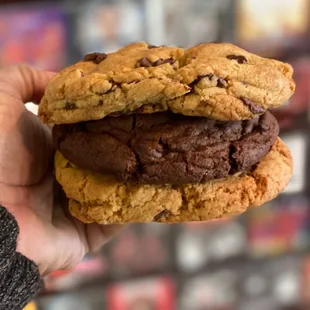 a hand holding a chocolate chip cookie sandwich