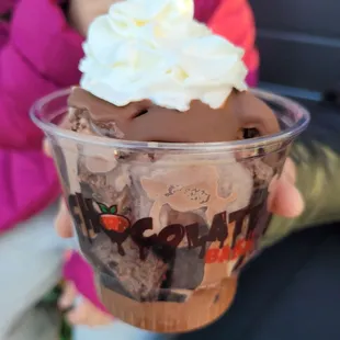 a person holding a cup of ice cream