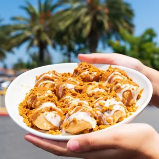 a person holding a bowl of dessert
