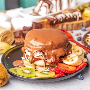 a plate of fruit and chocolate covered pancakes
