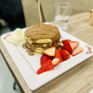 Pancakes with milk chocolate, strawberries and whip cream