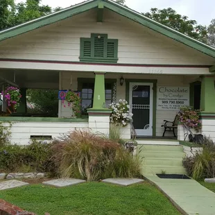 a small white house with green trim