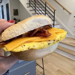 a hand holding a breakfast sandwich