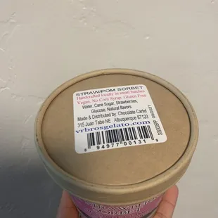 a hand holding a cup of ice cream