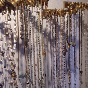 a collection of necklaces hanging on a wall